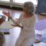 A yoga teacher in white leads a teacher training.