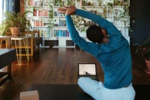 Man does a seated stretch on a Yoga mat